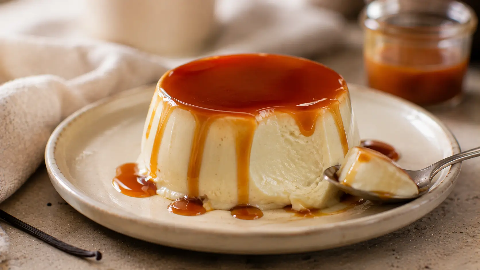 Silky caramel panna cotta topped with rich homemade caramel sauce on a ceramic dessert plate.